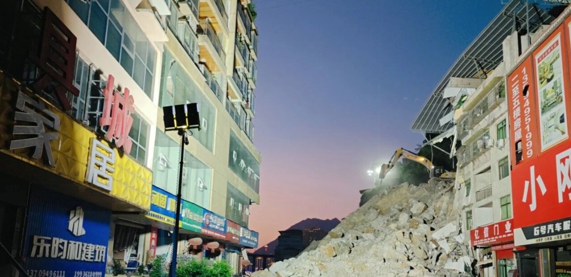 Debris clearance and excavation in an urban street after a landslide