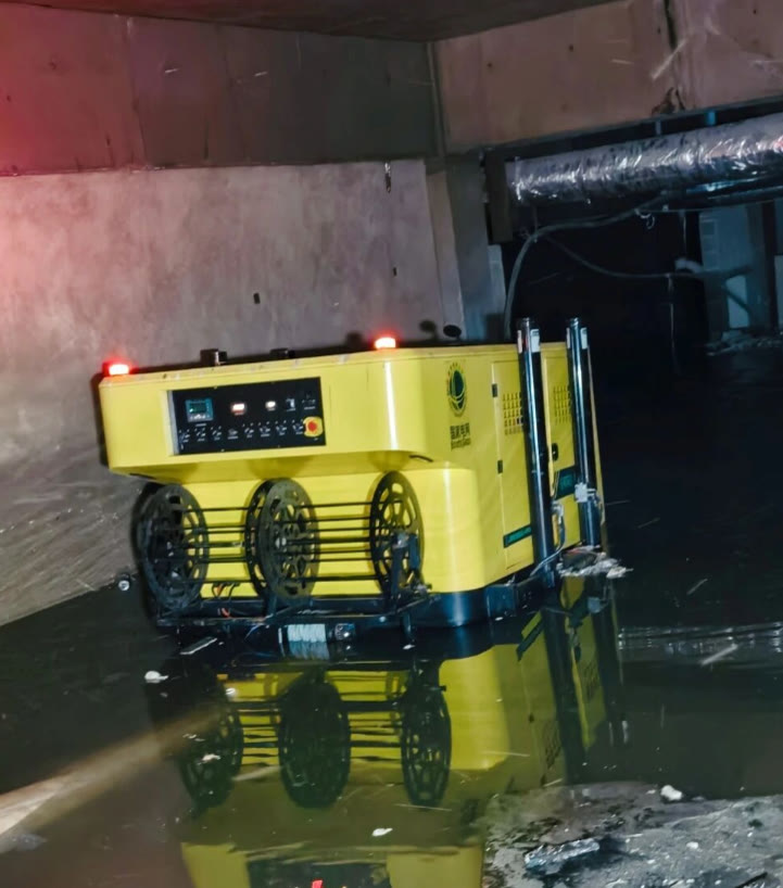 Tracked drainage robot positioned at the edge of deep water in an underground space