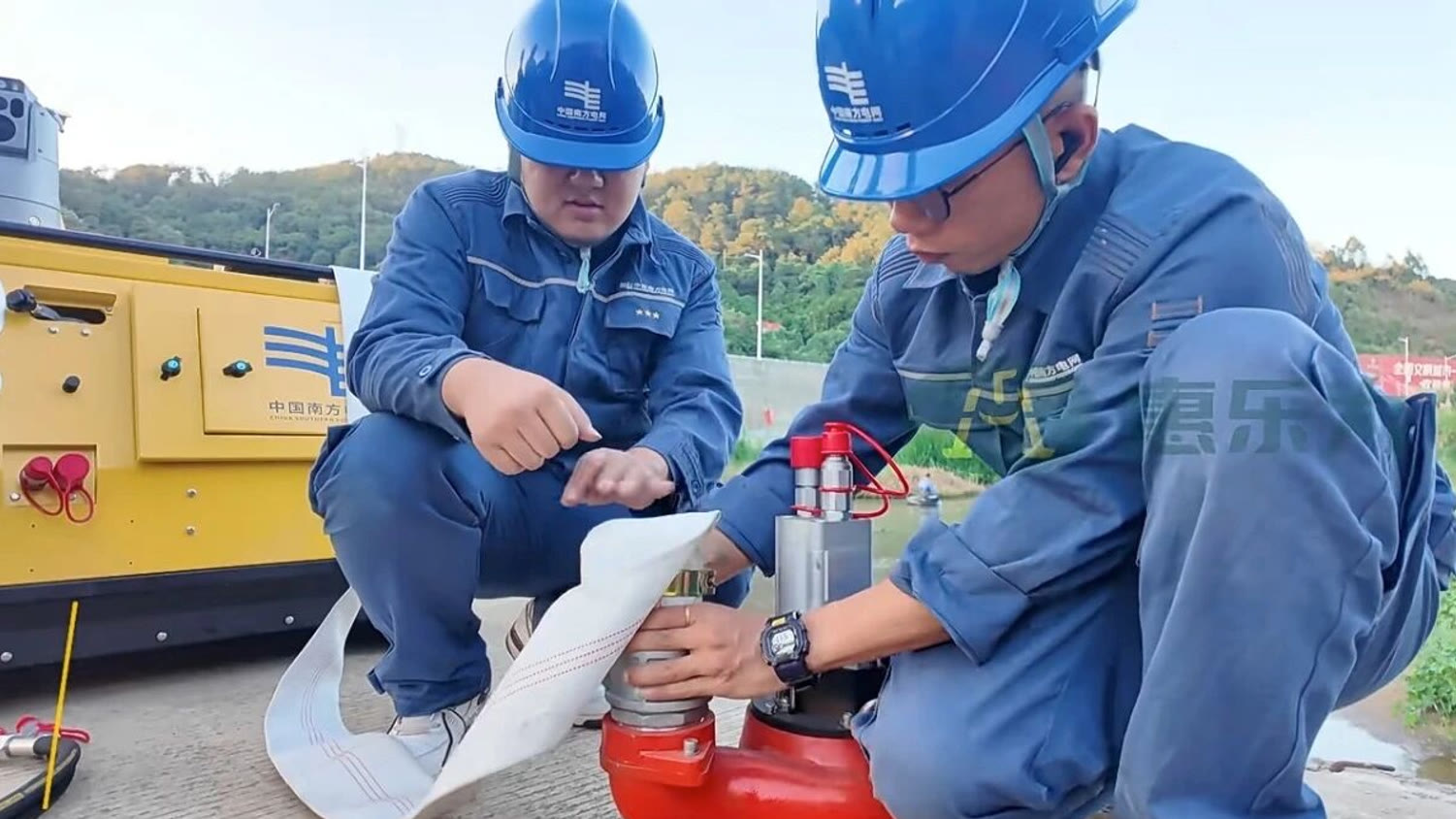 Crew connecting a discharge hose to pumping equipment at an emergency drainage operation